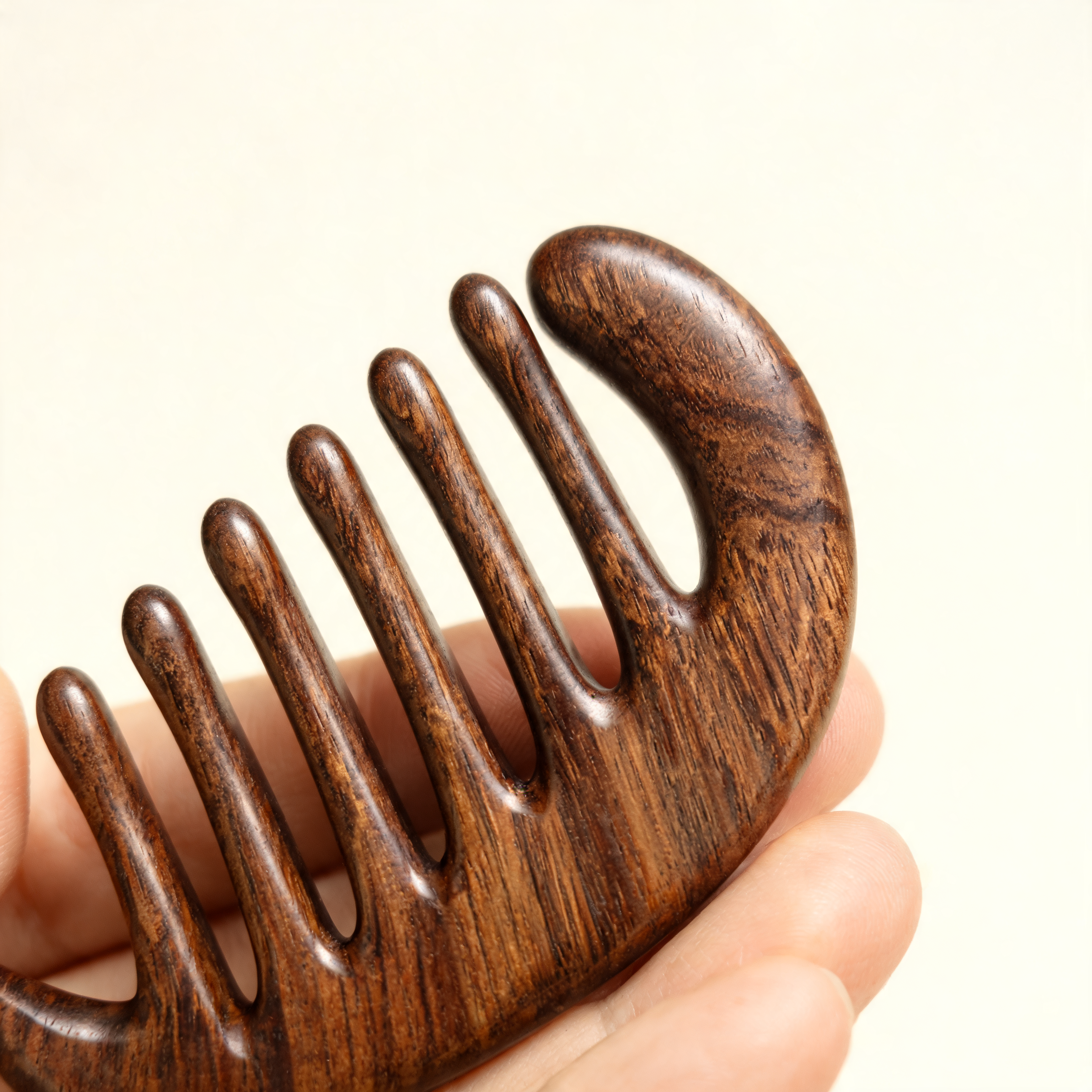 Close-up of the rounded polished teeth of the scalp massage comb