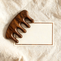 Wooden scalp massage comb with VIP membership card on cream linen